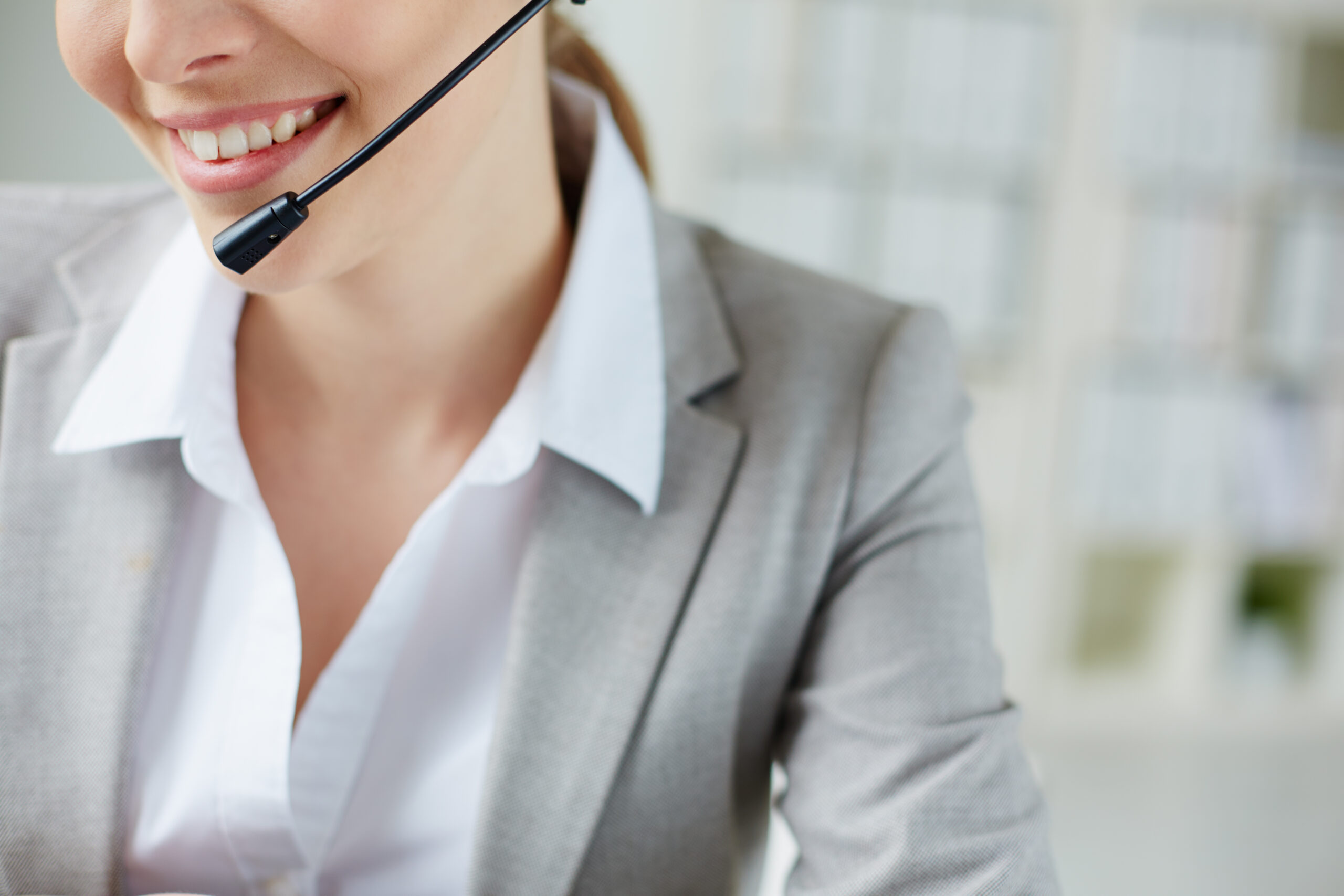 Toothy smile of young businesswoman with headset